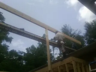 Carpenter setting a ridge beam over a new addition frame — Ice Dam Removal by Roofing Brothers in Mitchellville