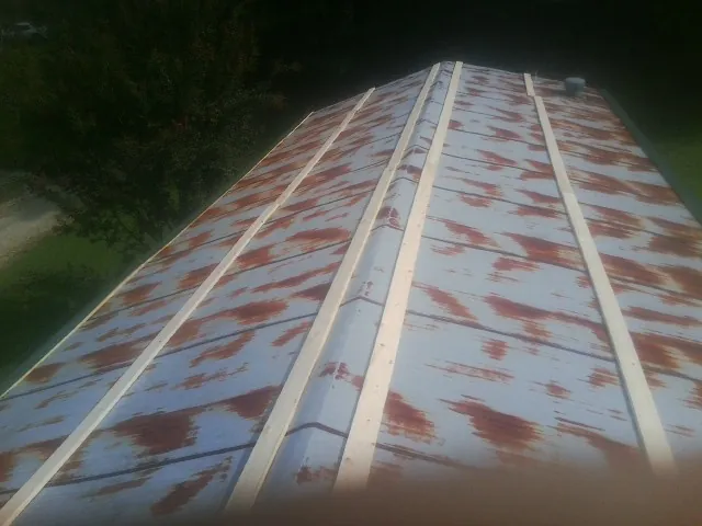 Rusted metal roof panels with new wood purlins before replacement — Storm Damage Roof Repair in Mitchellville by Roofing Brothers