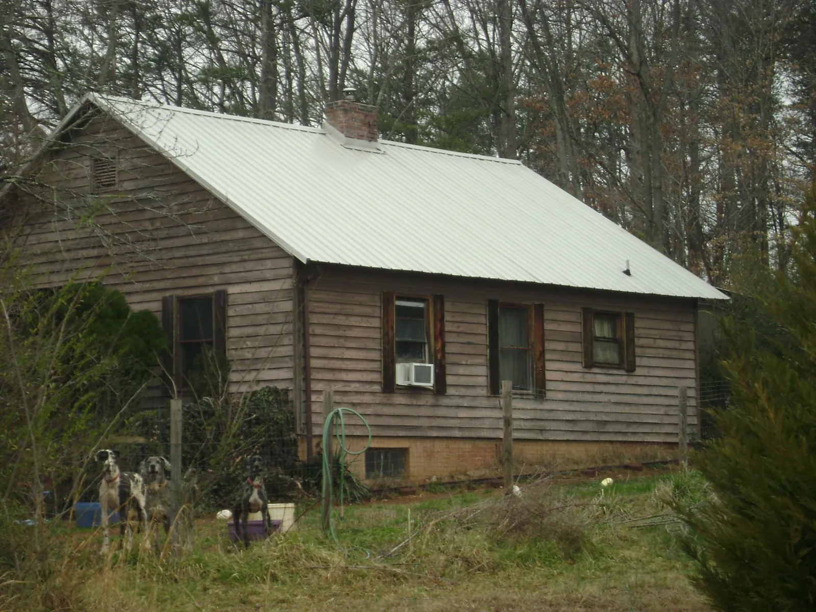 White metal roof on an old wood sided farmhouse, from a Metal Roof Installation job in Mitchellville